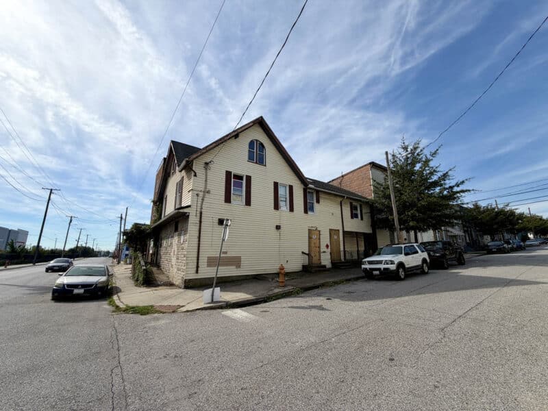 Side exterior of 4900 Curtis Avenue showing the two-and-one-half-story mixed-use building along Cherry Street in Curtis Bay.