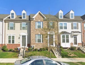 Front exterior of 4305 Plinlimmon Drive, a brick and siding townhome in the Ballard Green community of Owings Mills, Maryland
